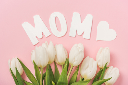 white tulips, paper word mom and paper hearts on pink backgroundの写真素材