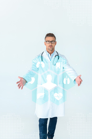handsome doctor in glasses standing with open arms and medical interface isolated on whiteの写真素材