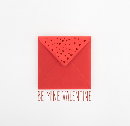 flat lay with red envelope isolated on white, st valentine day concept with "be mine valentine" letteringの写真素材
