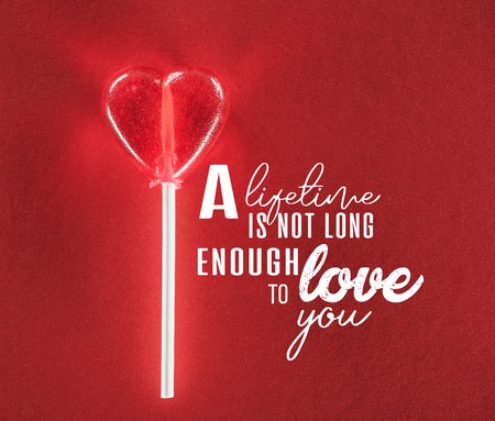close-up view of heart shaped candy on red background with a lifetime is not long enough to love you...