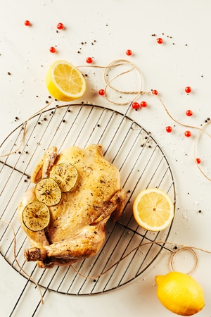 top view of fried chicken and lemons on metal grille with berries and stringの写真素材