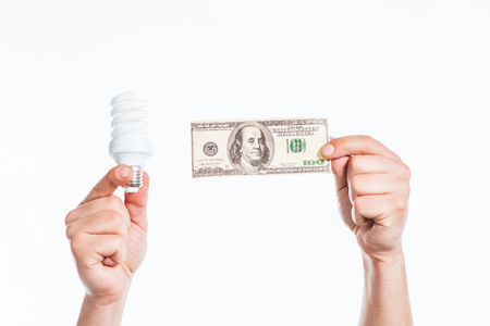 cropped view of male hands holding fluorescent lamp and hundred dollar banknote in hands isolated on...