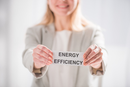selective focus female hands holding card on white background, energy efficiency conceptの写真素材