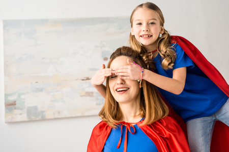 Cute daughter playing with mother at homeの写真素材