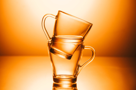 selective focus of two cups of water on orange backgroundの写真素材