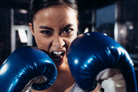 close up view of shouting girl in boxing glovesの写真素材