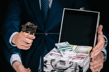 cropped shot of businessman holding iron vise tool with russian ruble coin and suitcase safe box with banknotesの写真素材