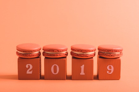 coral cubes with 2019 numbers and macarons on coral background, color of 2019 conceptの写真素材