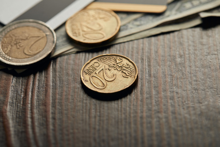 selective focus of coins with dollar banknotes and credit cards on backgroundの写真素材