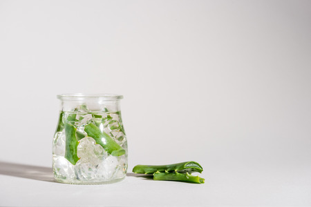 Studio shot of glass jar containing aloe vera leaves and iceの写真素材