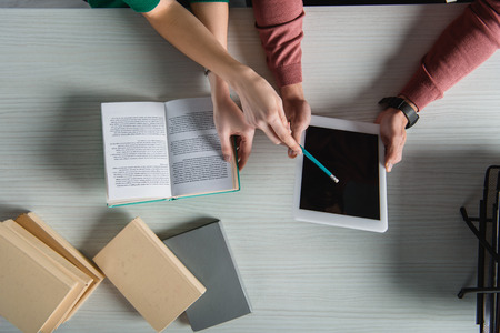 top view of woman pointing at digital tablet with blank screen with pencil near booksの写真素材