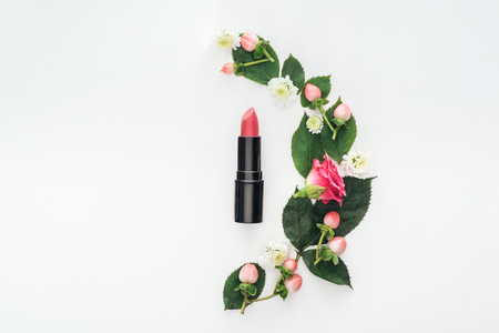 top view of composition with leaves, roses, berries, hrysanthemums and pink lipstick isolated on whiteの写真素材