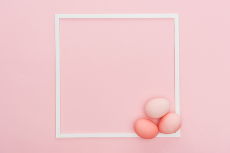 top view of pastel easter eggs with empty frame isolated on pinkの写真素材