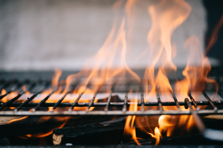 burning firewood with flame through bbq grill grates
