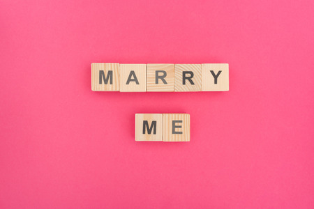 top view of marry me lettering made of wooden cubes on pink backgroundの写真素材