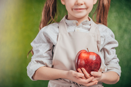 cropped view of child holding apple on blurred background, earth day conceptの写真素材