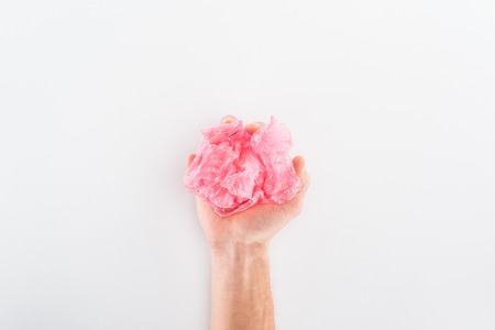 Partial view of man holding pink plastic bag on grey backgroundの写真素材