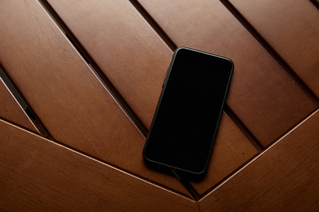 top view of smartphone with blank screen on wooden tableの写真素材