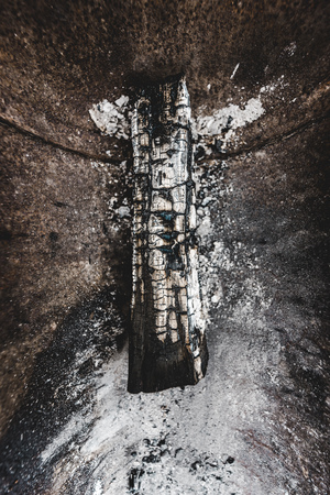 top view of burnt wooden log covered with white ash