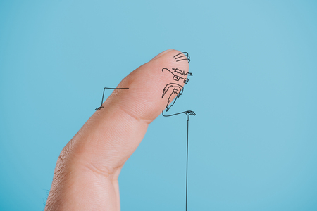 cropped view of one finger as senior person isolated on blueの写真素材