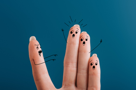 cropped view of scared yelling fingers and zombie isolated on blueの写真素材