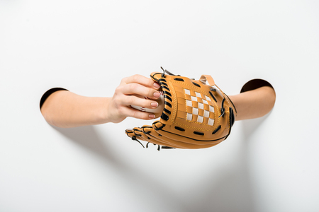 cropped image of sportswoman holding baseball glove and ball through holes on whiteの写真素材