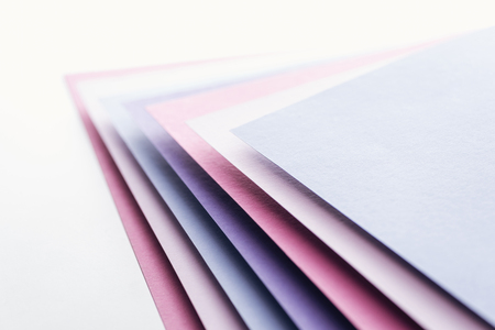 blue, white, pink and purple sheets of paper on white backgroundの写真素材