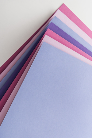 top view of blank and empty blue, white, pink and purple sheets of paper on white background