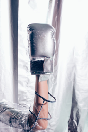 cropped view of girl with silver box glove on hand on metallic backgroundの写真素材