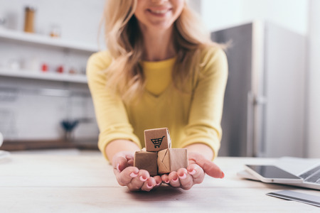 cropped view of blonde woman holding decorative packages in handsの写真素材