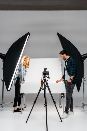 side view of young photographers working with professional equipment in photo studioの写真素材