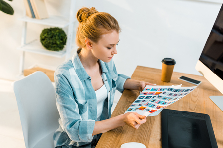 high angle view of young retoucher working with photos in officeの写真素材