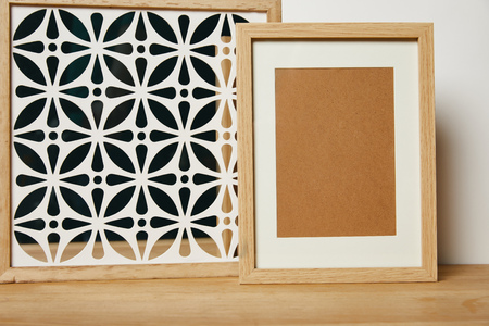 blank frame near decorative ornate frame on tableの写真素材