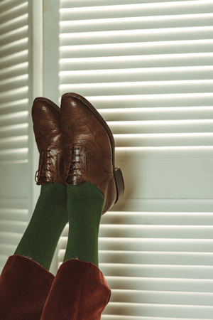 partial view of female legs in retro leather shoes near folding screenの写真素材