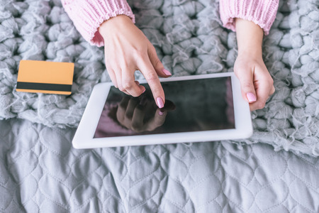 cropped view of woman holding credit card and digital tablet with blank screenの写真素材
