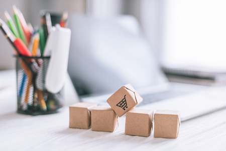 close up of decorative packages with shopping cart sign on wooden desk