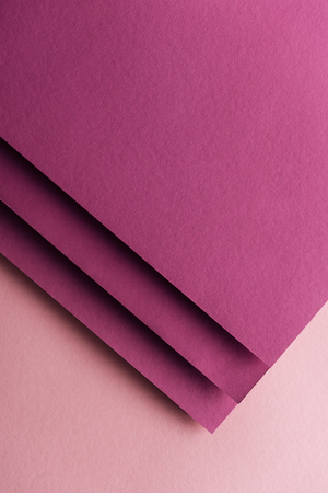 top view of blank and colorful burgundy sheets of paper on pink background with copy spaceの写真素材