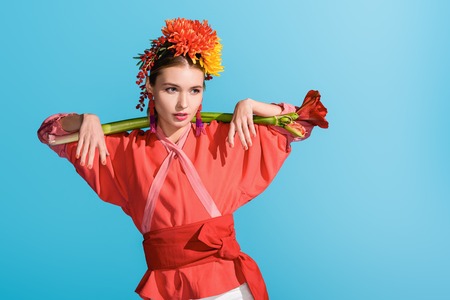 beautiful elegant girl in wreath holding living coral flower isolated on blue. Color of the year...