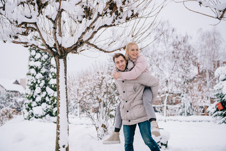 playful couple spending time in snowy parkの写真素材