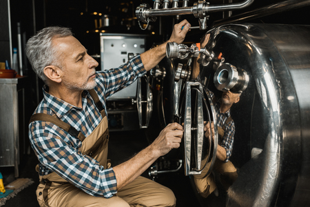 senior male brewer working with brewery equipmentの写真素材