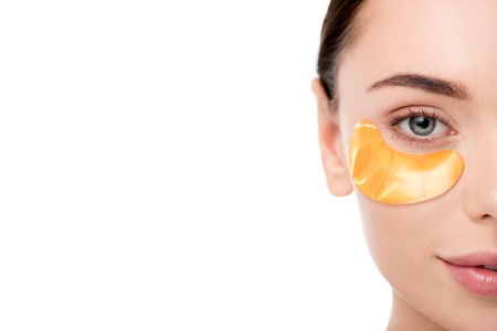 cropped view of beautiful woman with golden eye patch isolated on white with copy space