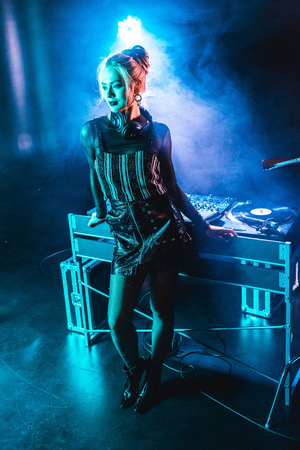 beautiful dj girl standing near dj equipment in nightclub with smokeの写真素材