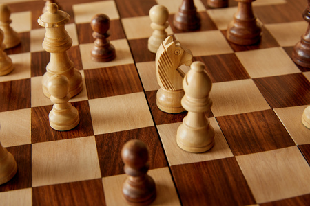 chess pieces on wooden brown chess board