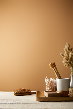 wooden tray with different hygiene and care items, and hair brush isolated on brown, zero waste conceptの写真素材