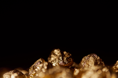 selective focus of gold stones isolated on blackの写真素材