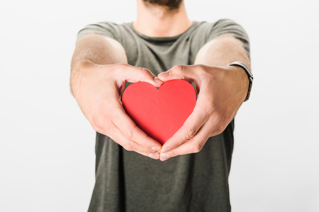 Cropped view of man in grey t-shirt holding paper heartの写真素材