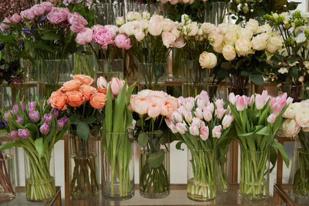 roses, tulips and peonies in glass vasesの写真素材