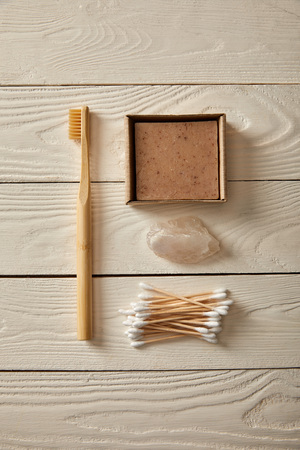 top view of different hygiene and care items on white wooden surface, zero waste concept
