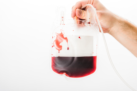 Cropped view of man holding drip with blood on white background, blood donation conceptの写真素材