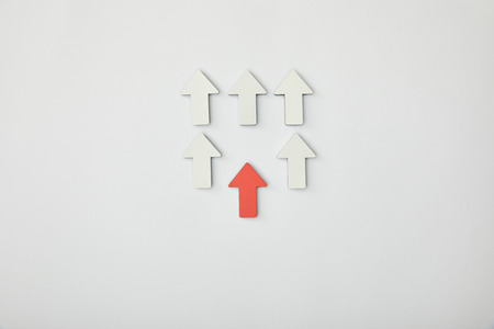 top view of red arrow near rows with white pointers on grey background